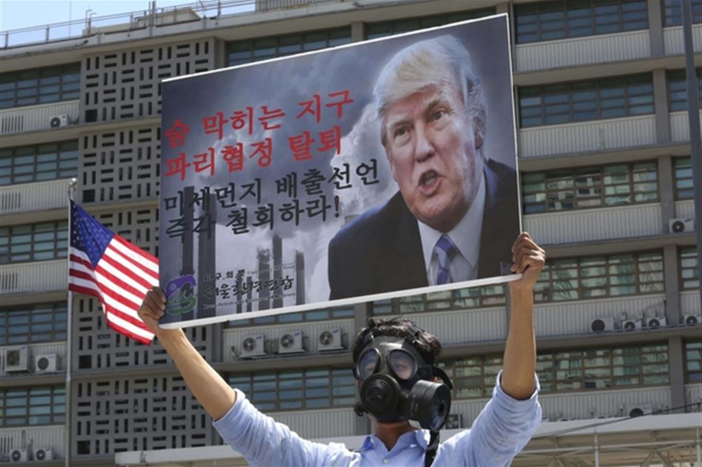 Un manifestante coreano protesta contro Trump dopo le decisioni prese sul clima al vertice di Parigi