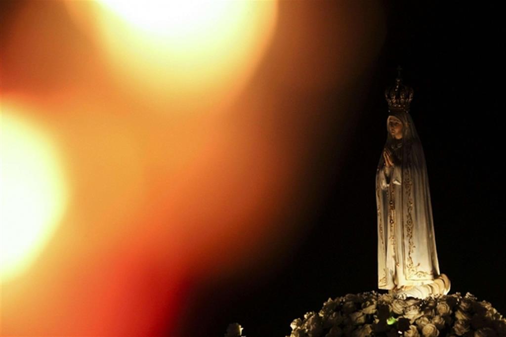 La Madonna di Fatima, durante la processione delle candele ieri sera, 12 ottobre, in Portogallo (Ansa)