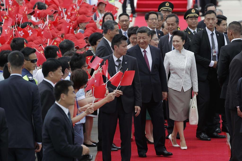 Il presidente cinese Xi Jinping, in compagnia della moglie Peng Liyuan, dopo lo sbarco a Hong Kong (Ansa)