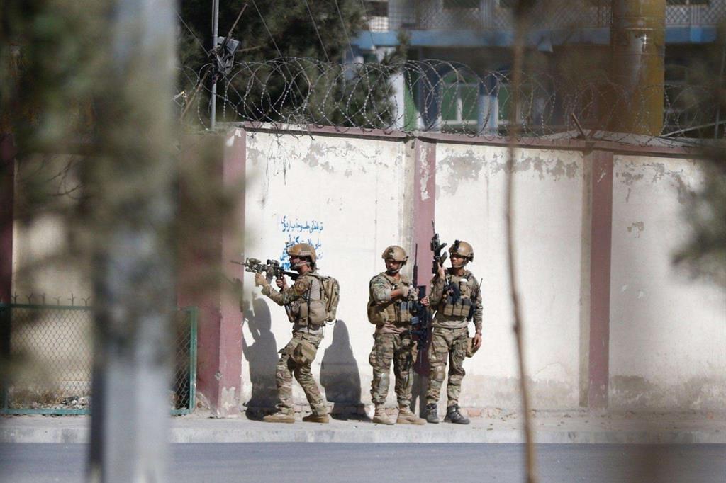 Forze di sicurezza afghane appostate all'ingresso di Shamshad tv durante l'attacco (Ansa)