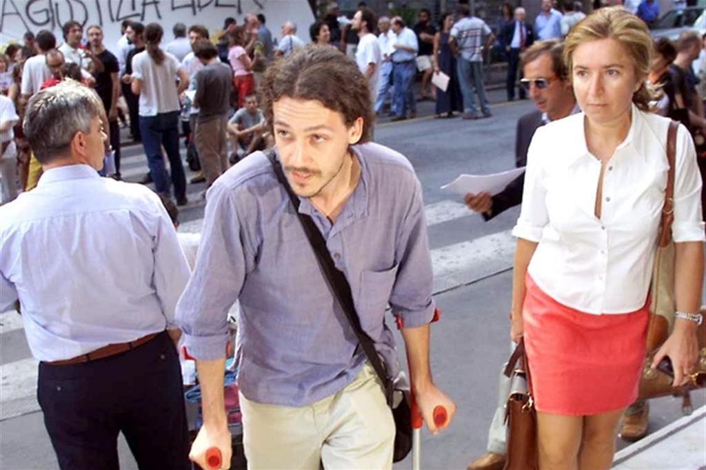 Una delle persone picchiate nella caserma a Bolzaneto (a sinistra) entra in tribunale con il suo avvocato (Ansa)