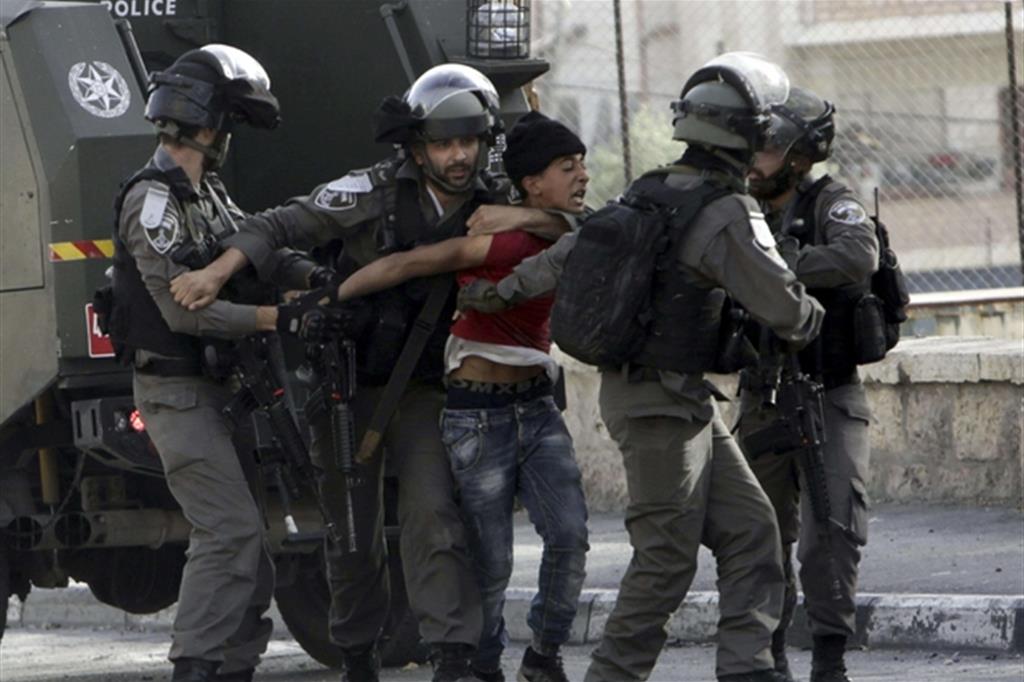 I soldati israeliani arrestano un ragazzo palestinese a Betlemme durante le manifestazioni in sostegno alla protesta dei detenuti (Ansa)
