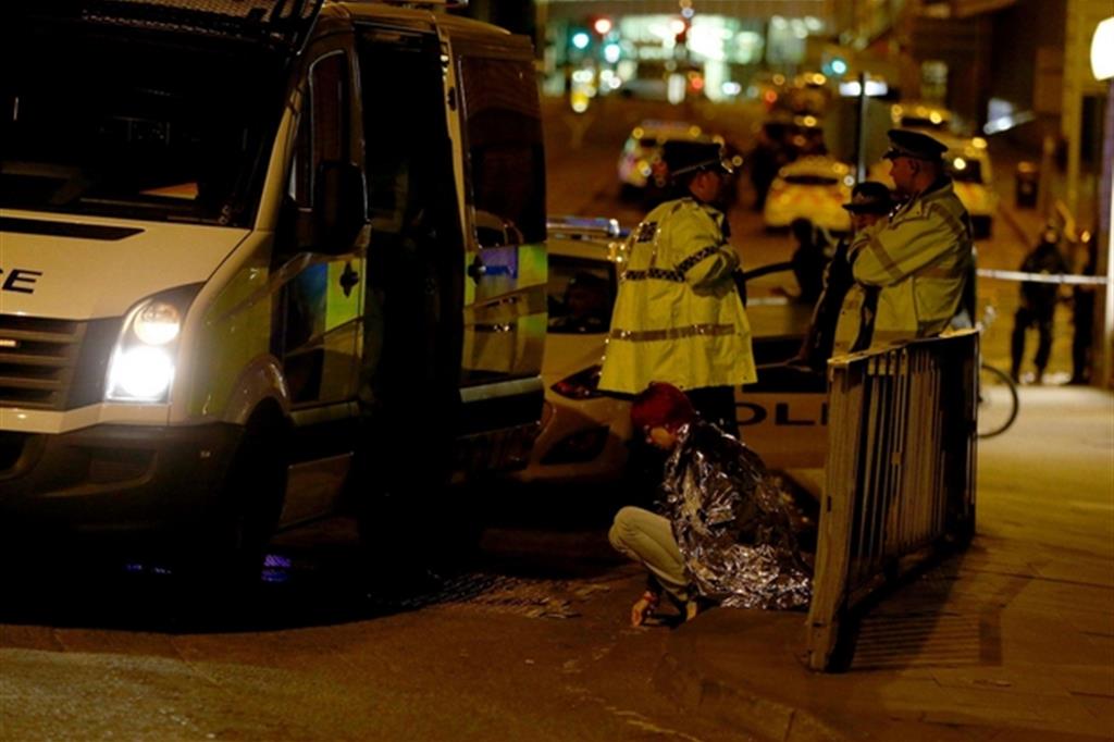 Una ragazza sotto choc soccorsa dalla polizia a Manchester (Ansa/Ap)