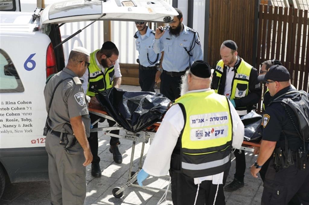 Il recupero di uno dei corpi degli assalitori che anno ucciso due poliziotti a Gerusalemme (Ansa)