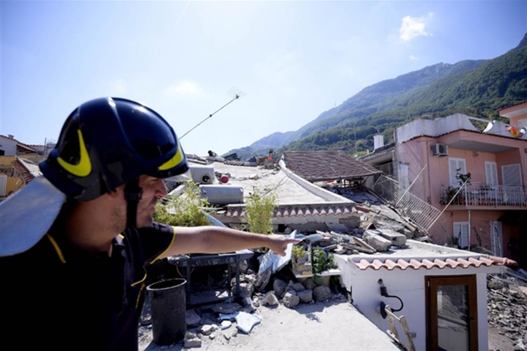 Un vigile del fuoco mostra i danni del recente terremoto a Ischia