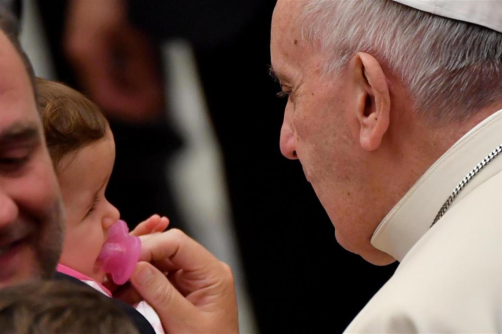 Papa Francesco con un neonato durante un'udienza generale nel novembre 2016 (Ansa)