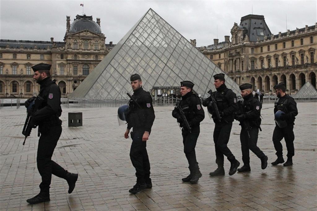 Agenti davanti alla piramide del Louvre a Parigi (Ansa/Ap)