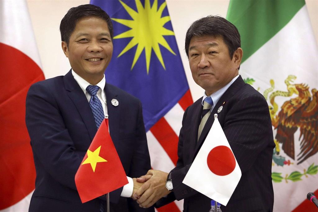 Il ministro del Commercio vietnamita, Tran Tuan Anh, e il ministro dell'Economia giapponese, Toshimitsu Motegi, annunciano il nuovo accordo trans-pacifico (Ansa-Ap)