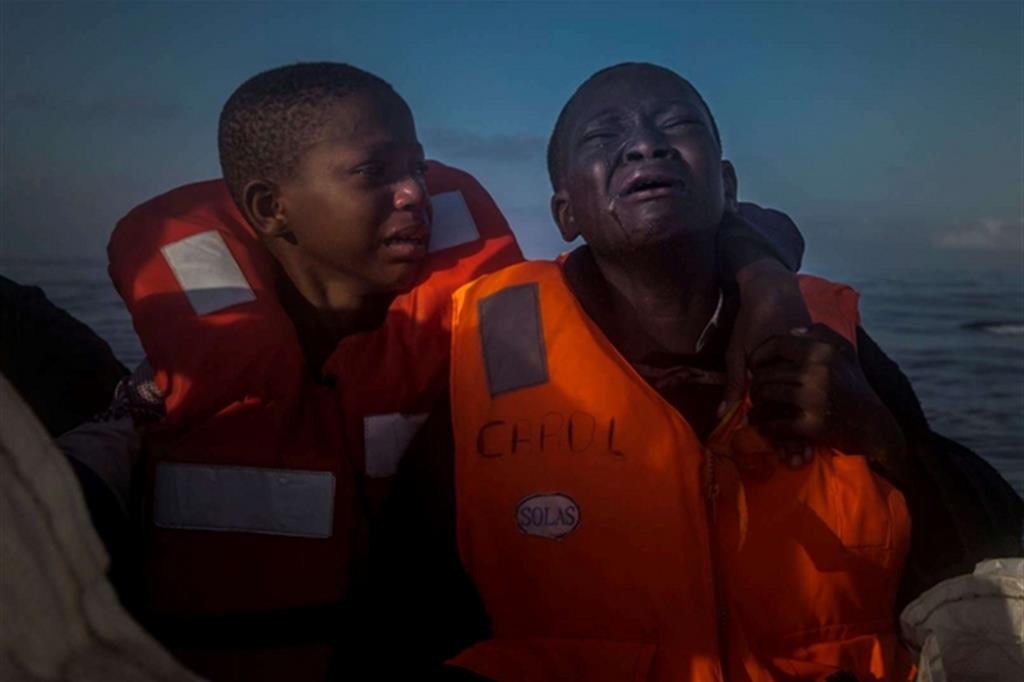 Operazione di soccorso nel Mar Mediterraneo, circa 23 chilometri a nord di Sabratha. Una bambina nigeriana di 11 anni (a sinistra), piange accanto al fratello di 10 anni, a bordo di una barca di salvataggio, il 28 luglio 2016. La  madre è morta in Libia e i bambini hanno navigato per ore su un gommone pieno di rifugiati. I contrabbandieri libici chiedono da 750 a 3500 euro per una traversata verso l'Italia. Foto Santi Palacios. - 