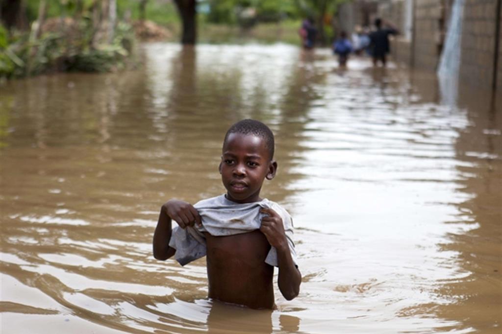 Un bimbo tra le acque a Fort-Liberte: ad Haiti l'uragano ha lasciato tremende alluvioni (Ansa)