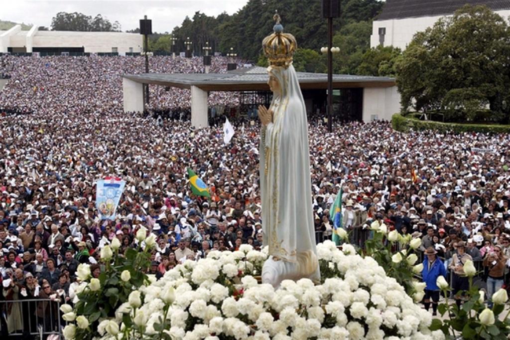 La statua della Vergine di Fatima passa tra i pellegrini raccolti nel suo Santuario (Ansa)