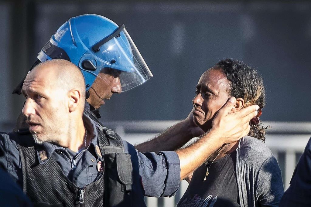 Un poliziotto consola una rifugiata sfrattata a Roma (Ansa) - 