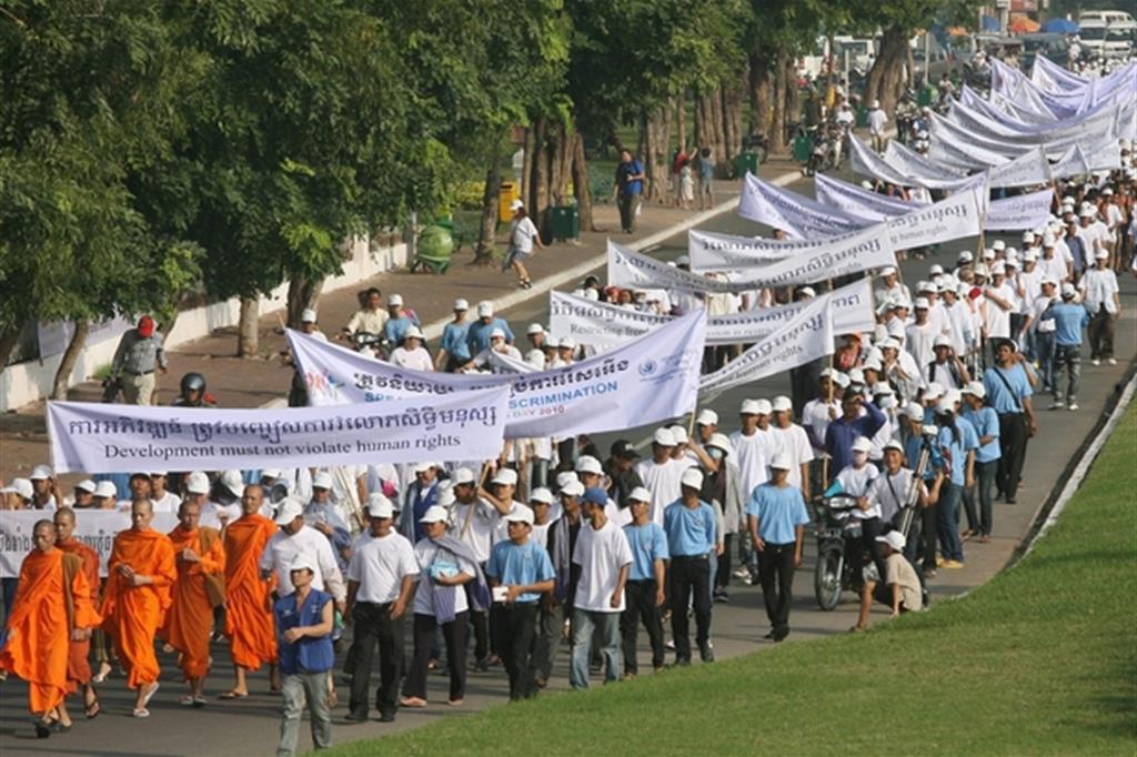 Attivisti per i diritti umani alzano striscioni durante una marcia per i diritti umani a Phnom Penh