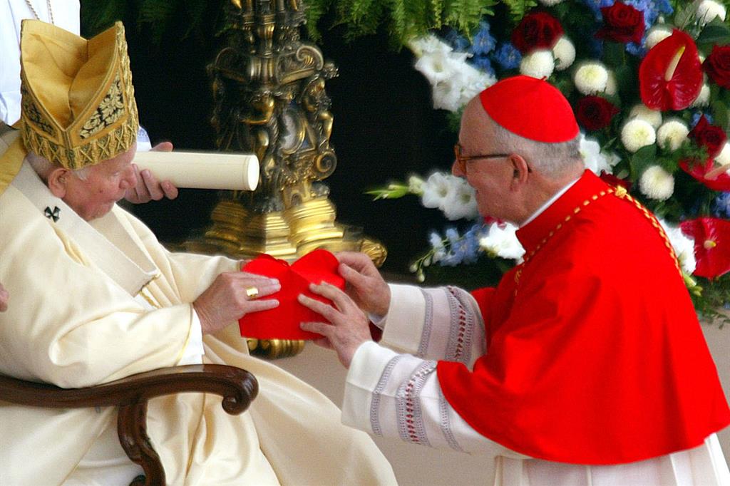 Monsignor Attilio Nicora mentre riceve da papa Giovanni Paolo II la berretta cardinalizia, il 21 ottobre 2003 (Foto Ansa)