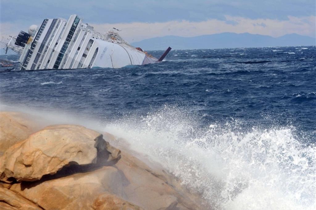La nave Costa Concordia adagiata su un fianco dopo il naufragio all'Isola del Giglio (Ansa)