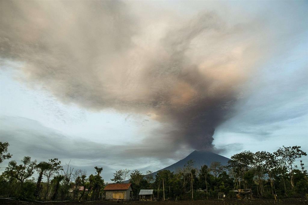 Il vulcano Agung, sull'isola di Bali, visto da un vicino villaggio (Ansa)
