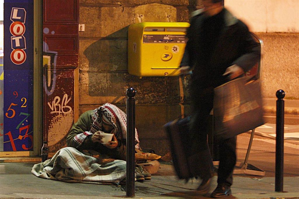 Un senzatetto in Francia si rifocilla con un pasto fornito dai volontari (Reuters)