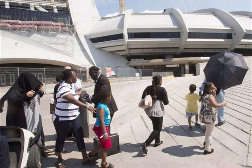 Un gruppo di richiedenti asilo fa ingresso nello stadio Olimpico di Montréal: sono 250 le persone attualmente ospitate