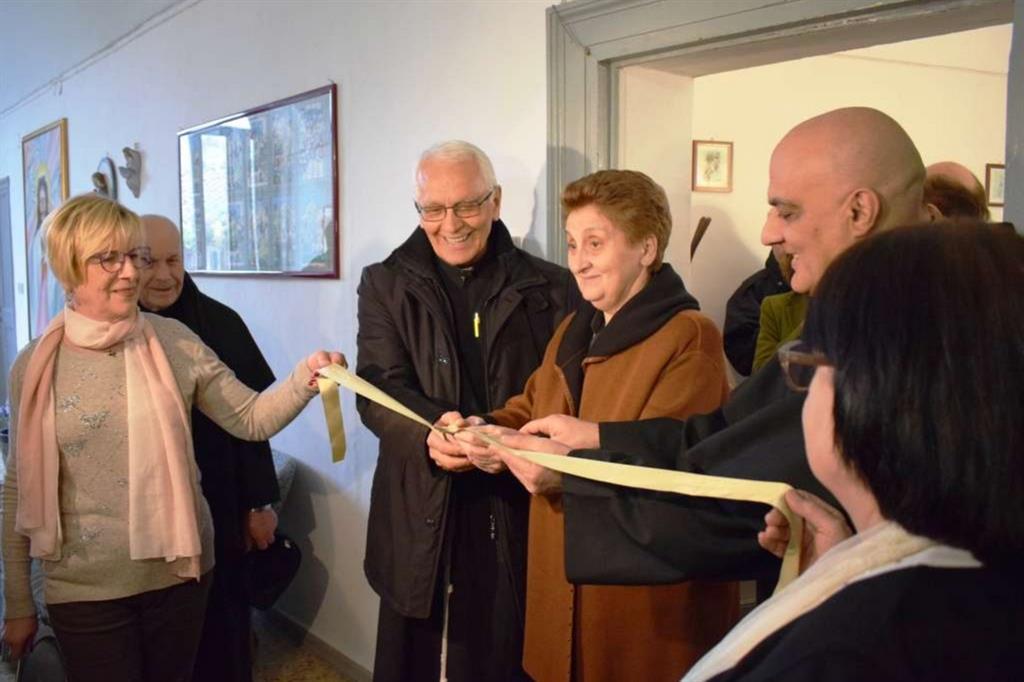 Il taglio del nastro. Al centro: padre Vittorio Trani e Mariella Enoc