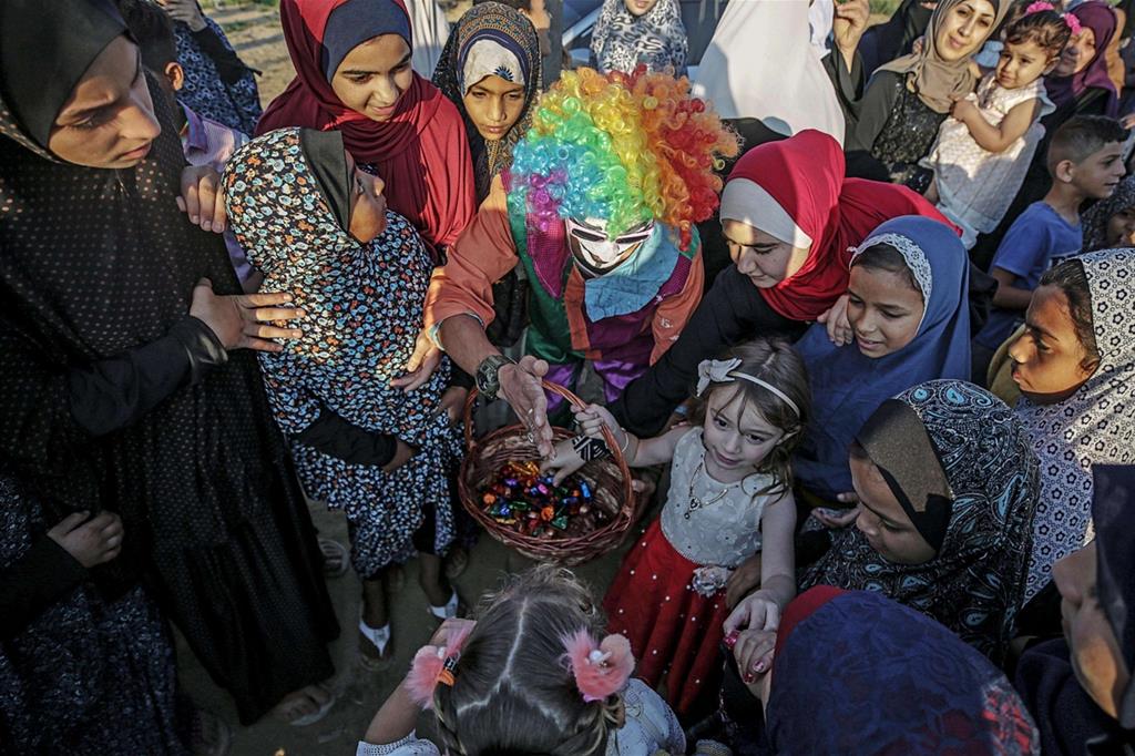 Un clown distribuisce dolcetti ai bambini della Striscia di Gaza. - 
