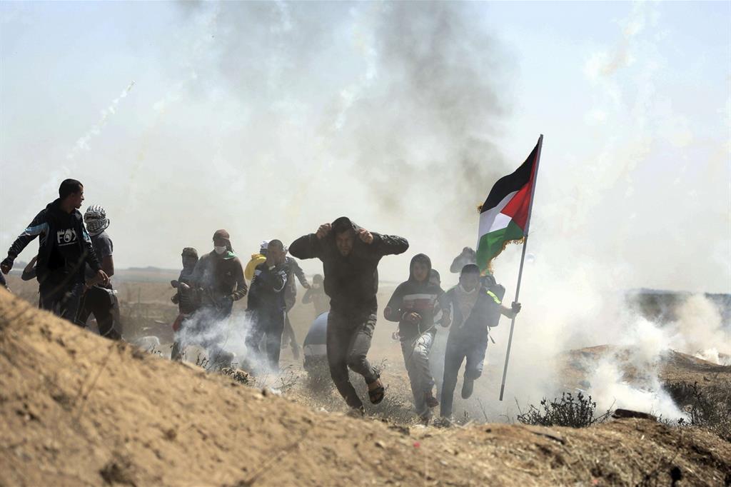 Manifestanti palestinesi fuggono dopo il lancio di gas lacrimogeni da parte dell'esercito israeliano (Ansa)