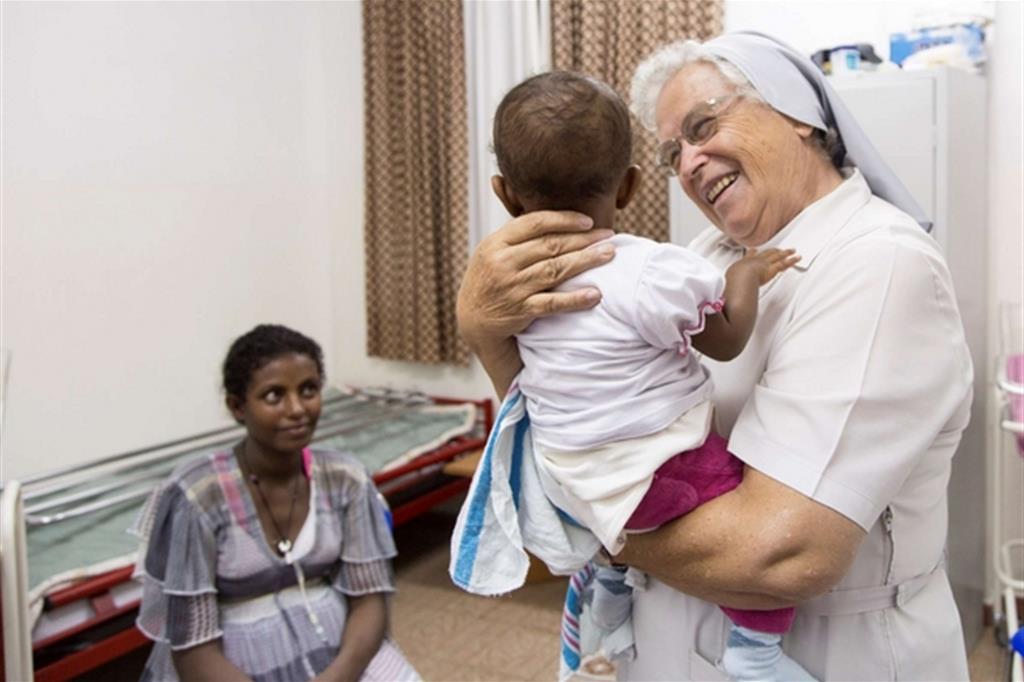 Suor Laura assiste un bimbo e sua madre nella missione salesiana di Adua