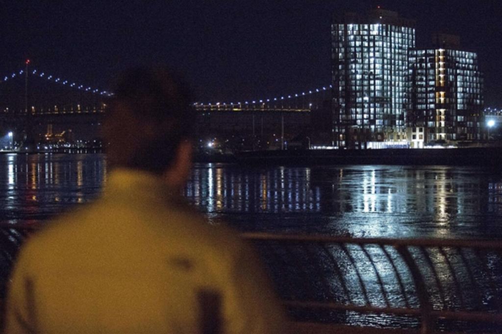 Un uomo guarda il punto dell'East River in cui è caduto l'elicottero (Epa)