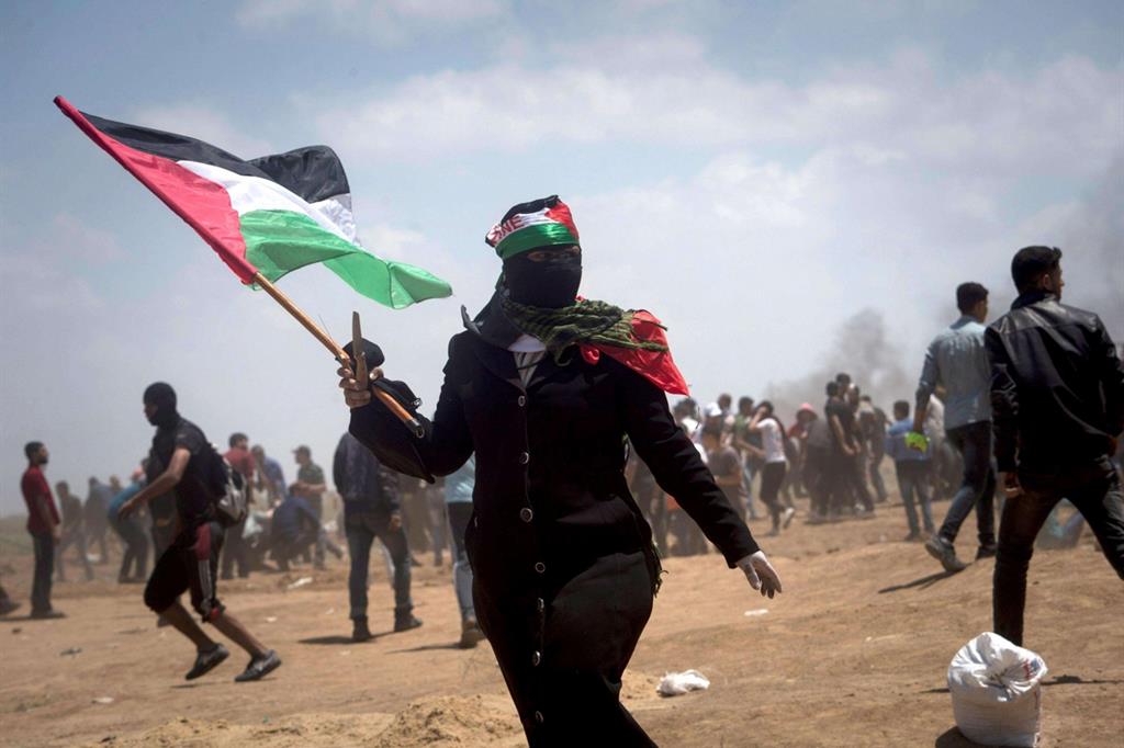 Una dimostrante con la bandiera dell'Autorità nazionale palestinese (Ansa)