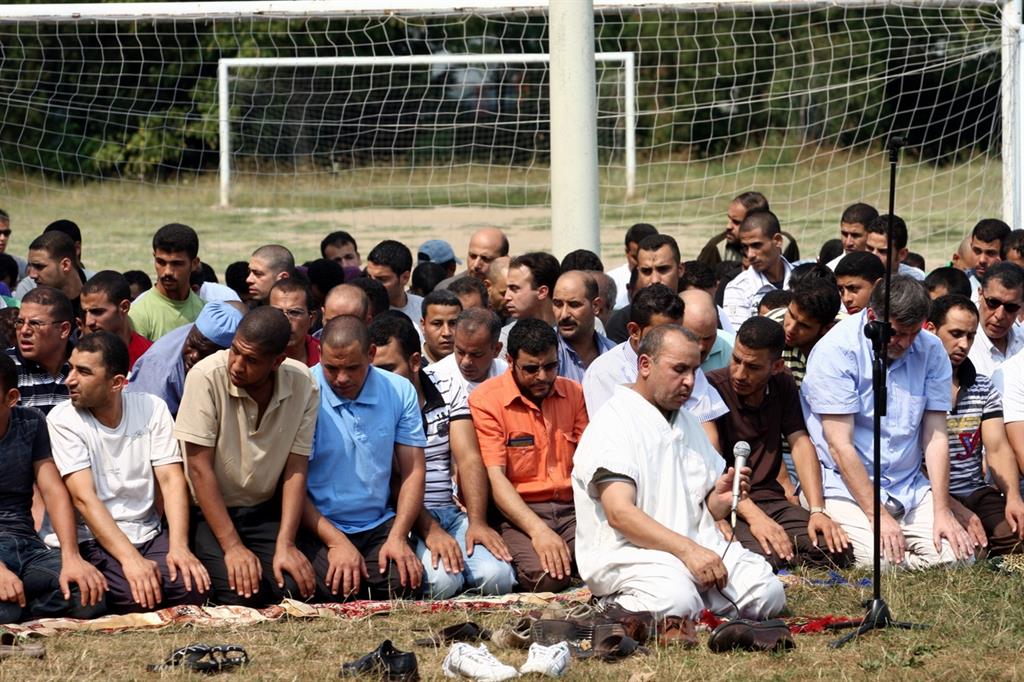 Musulmani in preghiera in un campo sportivo di MIlano (Foto archivio Fotogramma)