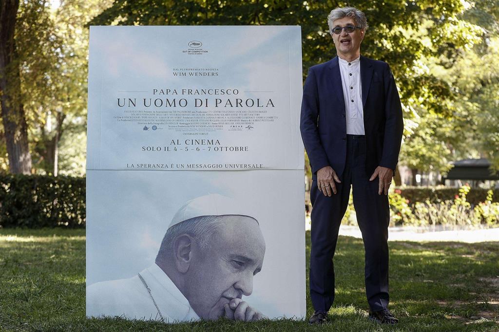 Wim Wenders davanti al manifesto del suo docufilm su papa Francesco