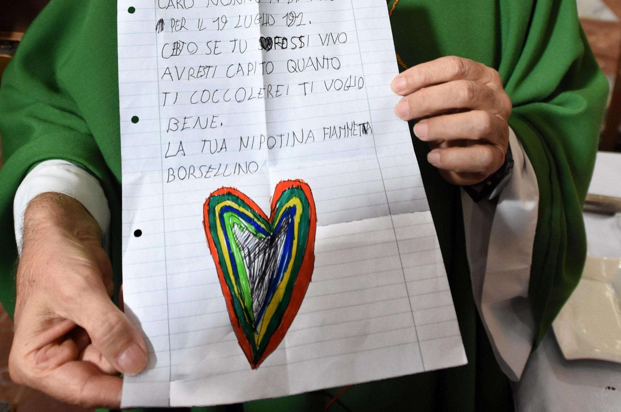 Don Scordato mostra la lettera della nipotina di Paolo Borsellino (Ansa)