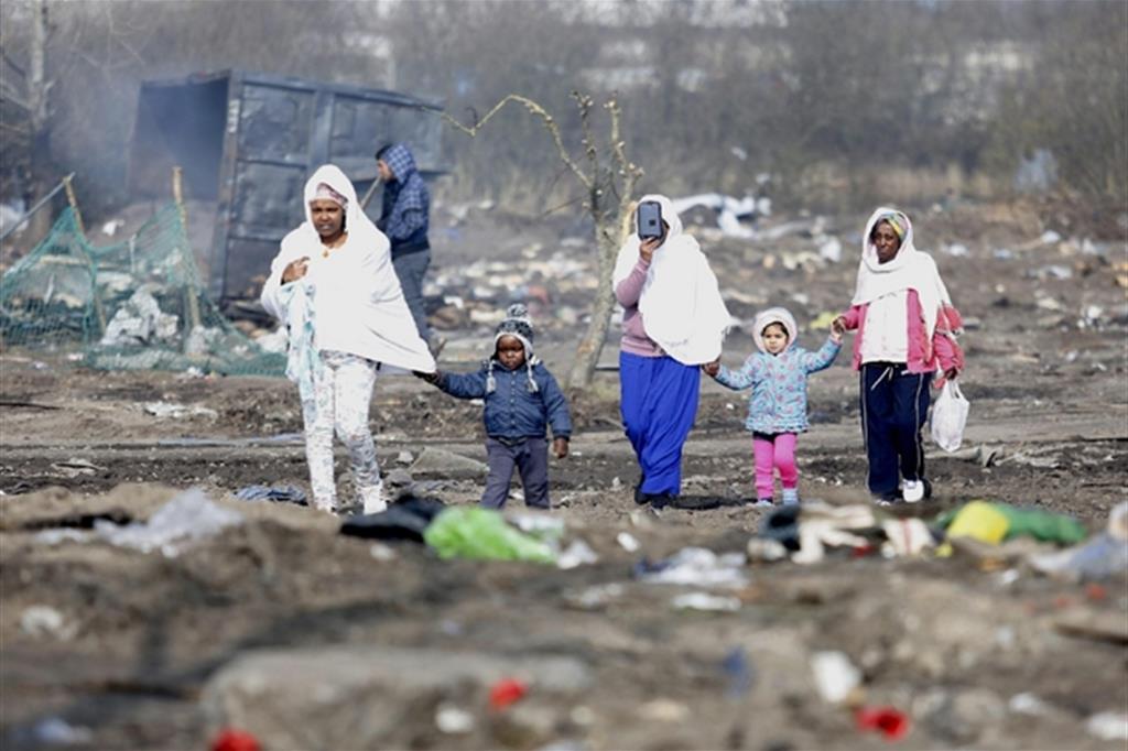 Madri con i figli tra i rifiuti sparsi nel campo di Calais sgomberato alla fine del 2016