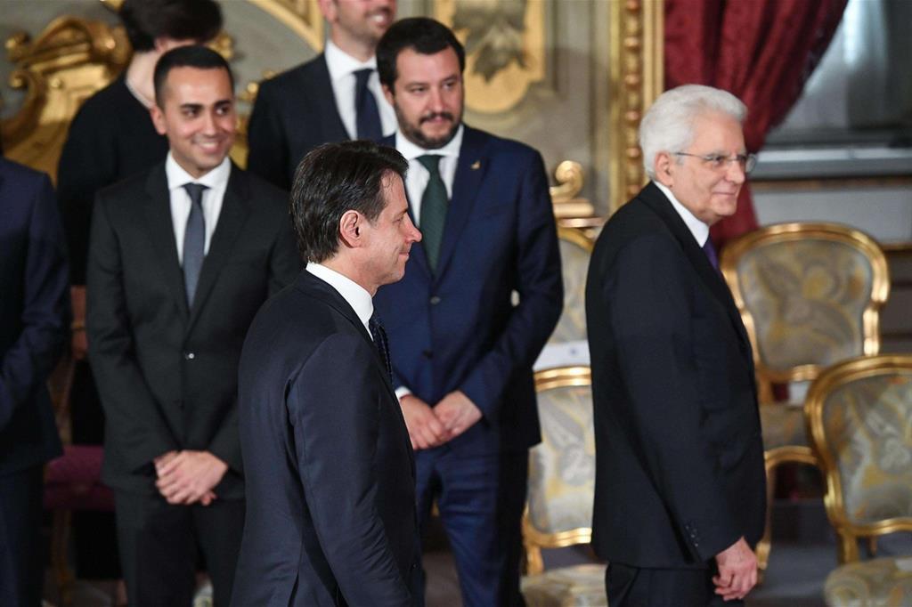 Il primo ministro Conte davanti ai suoi due vice, Di Maio e Salvini. Davanti a lui Mattarella (Ansa) - 