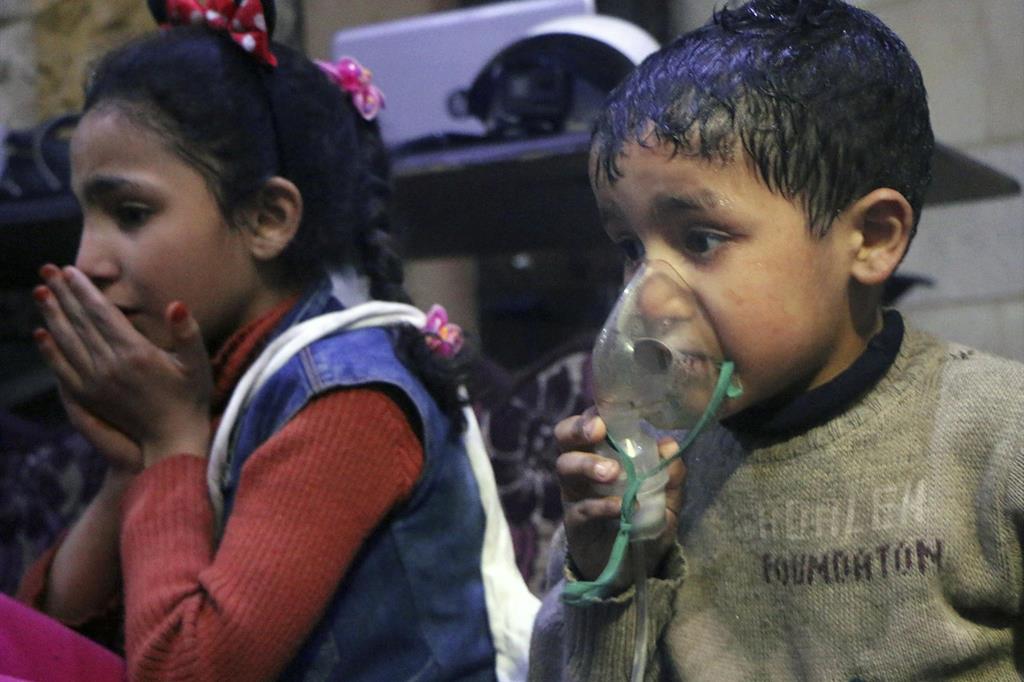 Bambini indossano mascherine antigas in una foto diffusa domenica 8 aprile dai Caschi bianchi, volontari civili siriani (Ansa)
