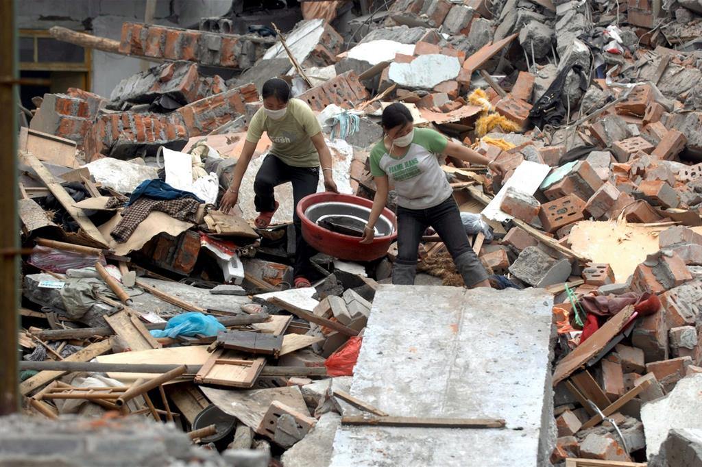 Due donne fra le macerie della città di Mianzhu nella provincia di Sichuan, dopo il terribile terremoto del 12 maggio (Ansa)