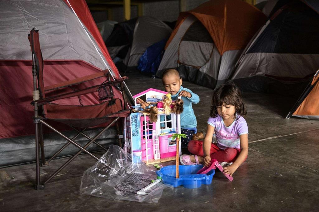 Piccoli originari del Guatemala giocano con i regali di Natale in un centro di raccolta alla frontiera tra Stati Uniti e Messico (Ansa)