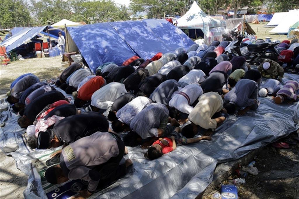La preghiera del venerdì tra le tende di un campo per sfollati a Palu, Sulawesi (Ansa)