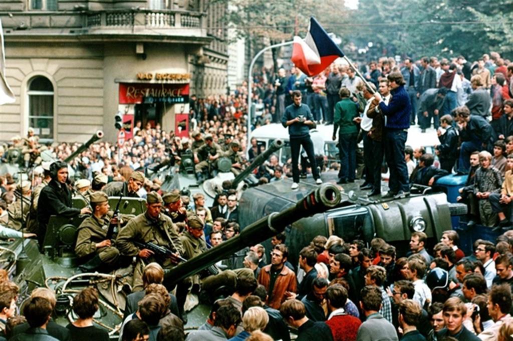 Gruppi  di manifestanti  cecoslovacchi  sventolano  pacificamente  le loro bandiere  sui carrarmati  sovietici  entrati a Praga  il giorno prima  per soffocare  la Primavera (Libor Hajsky/Ansa)