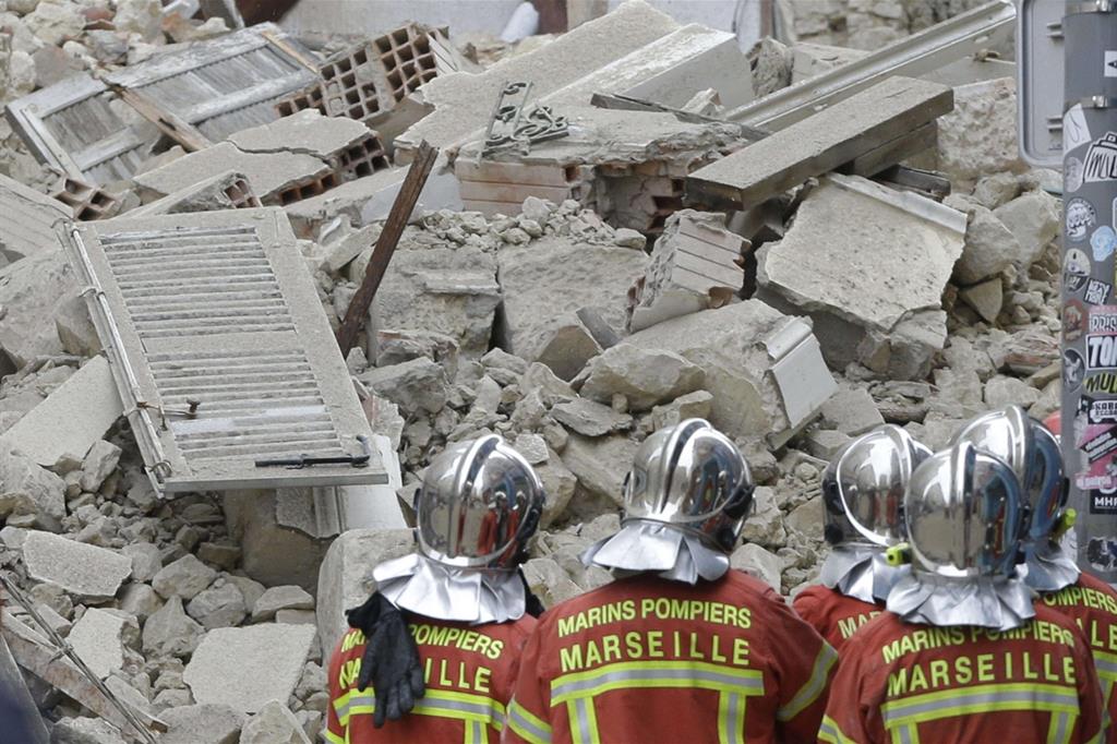 Vigili del fuoco al lavoro tra le macerie dei vecchi edifici crollati lunedì a Marsiglia (Ansa)