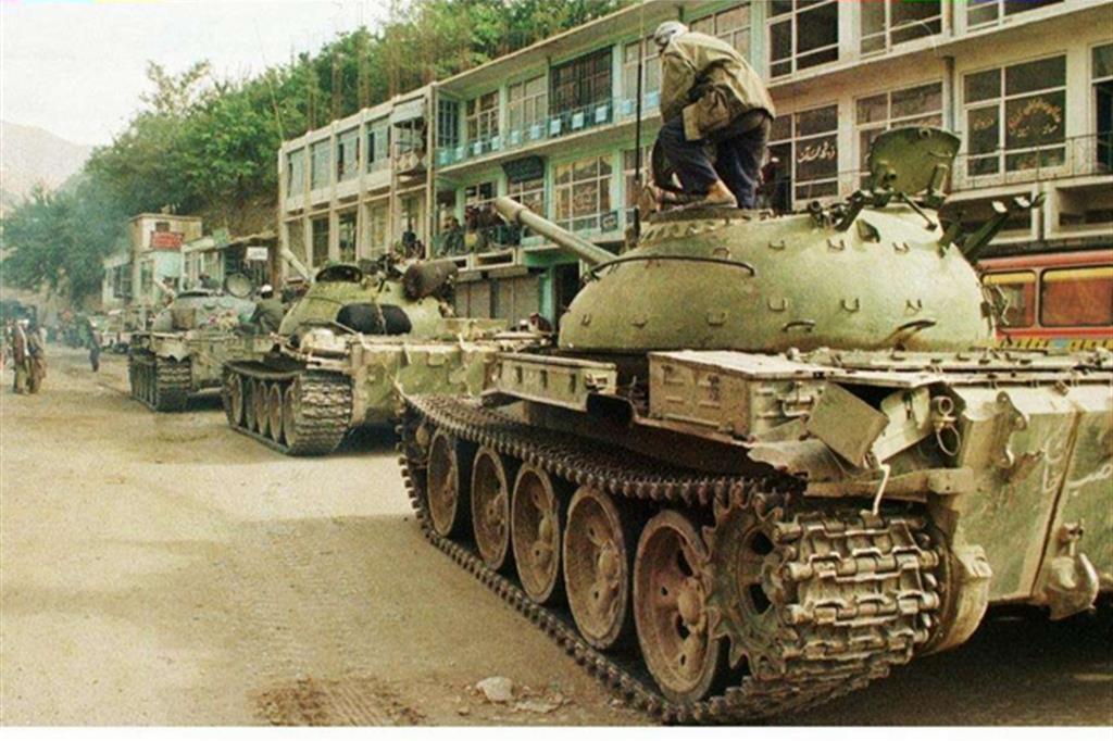 Dopo anni  di sanguinosa guerra, i taleban entrano vittoriosi  a Kabul il 26 settembre 1996 sui carri armati catturati ai russi. Saranno rovesciati da un intervento Nato nel 2001 (Ansa)