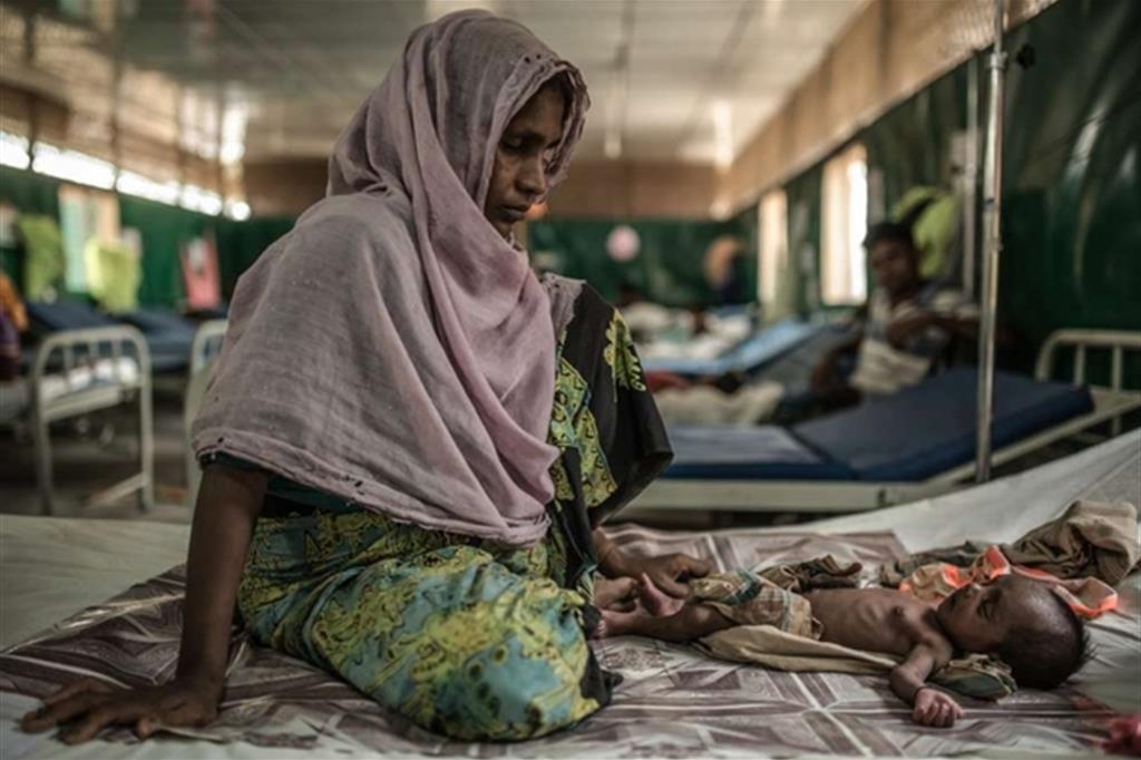 BANGLADESH, ROHINGYA – Foto di Pablo Tosco/Angular Rozia e suo figlio di due mesi Zubair si trovano nell'ospedale di MSF di Goyalmara, presso Cox's Bazar in Bangladesh. Molti dei bambini ricoverati in ospedale hanno contratto infezioni nei primi giorni di vita. Accade quando il parto avviene in scarse condizioni igienico sanitarie. Ancora oggi i Rohingya restano confinati con la forza nei campi e la maggior parte della popolazione di rifugiati ha scarso accesso all'acqua pulita, alle latrine, all'istruzione, alle opportunità di lavoro e all'assistenza sanitaria. - 