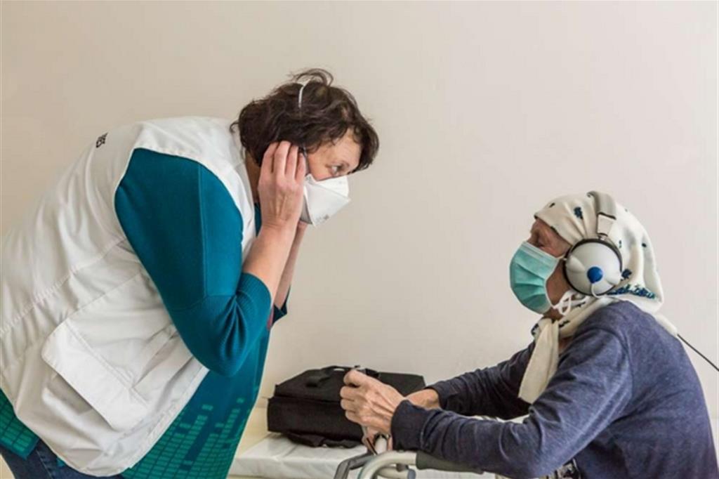 ZHYTOMYR, UCRAINA – Foto di Oksana Parafeniuk  Olena Markova, un'infermiera di MSF, spiega a Lidiia Andriienko, 78 anni, come sostenere il test dell'udito presso il centro regionale per la cura della tubercolosi di Zhytomyr in Ucraina. Alcuni farmaci utilizzati nel trattamento della TB possono infatti comportare gravi effetti collaterali, compresa la perdita dell'udito. - 