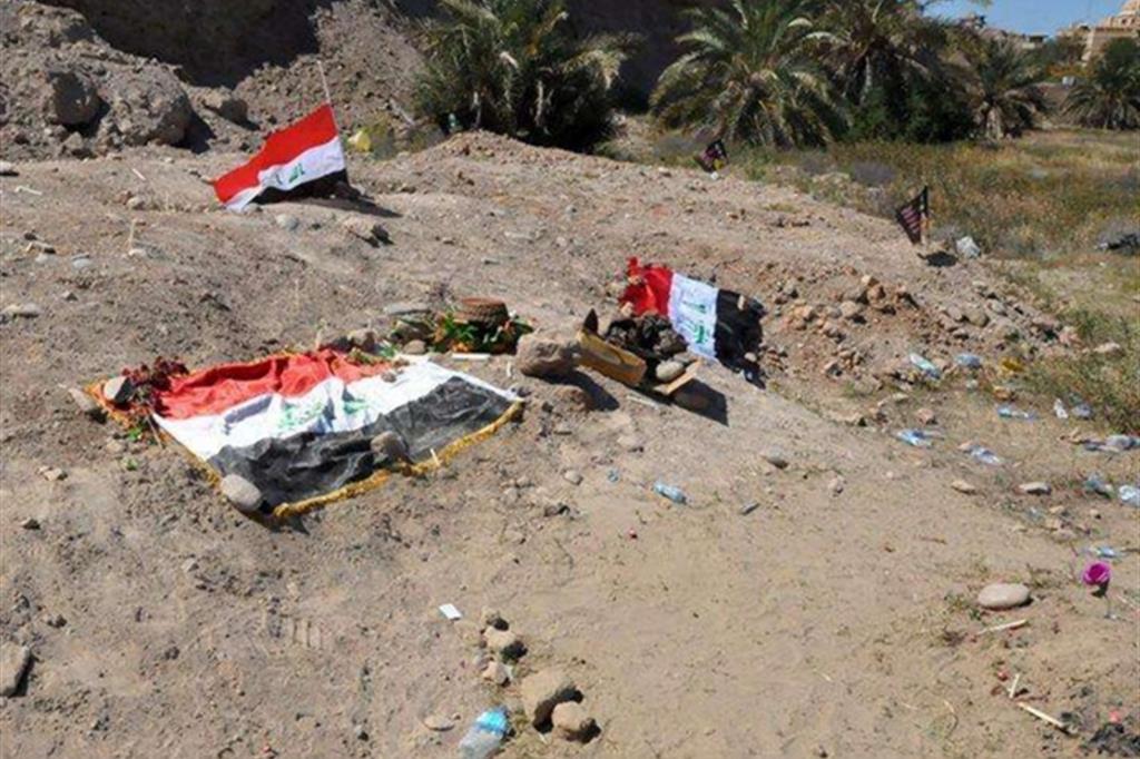 Alcune bandiere irachene su un sito identificato come fossa comune del Daesh a Tikrit (Epa)