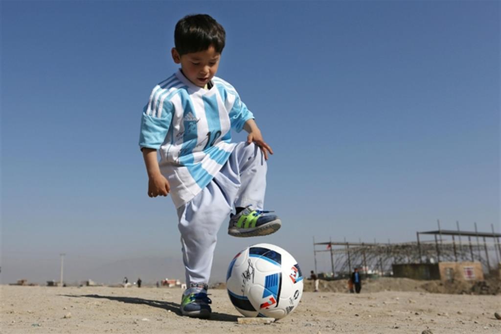 Il piccolo Murtaza Ahamadi con la maglia autografata da Messi (Ansa)