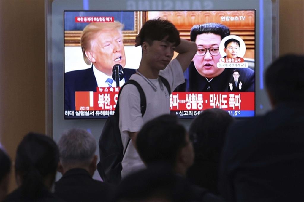 Le foto di Donald Trump e Kim Jong-un in uno maxi-schermo tv alla stazione dei treni di Seul (Ansa)