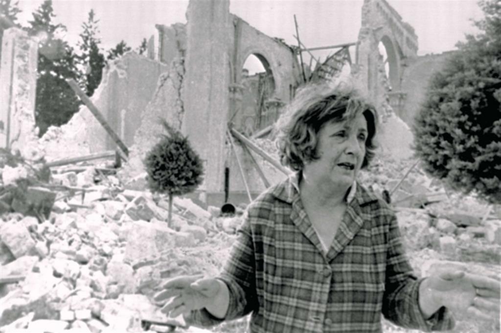 Una sopravvissuta del terremoto in Friuli si aggira tra le rovine di Tarcento (Ansa)