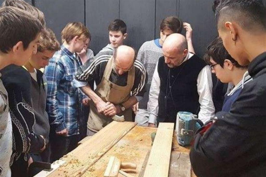 Maestri artigiani e studenti del corso di falegnameria promosso dalla Fondazione Cometa alla scuola professionale Oliver Twist di Como