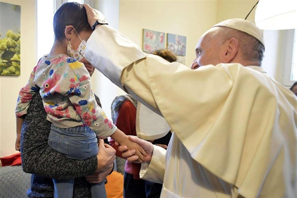 Il Papa con un piccolo malato di “Casamica” (Ansa)
