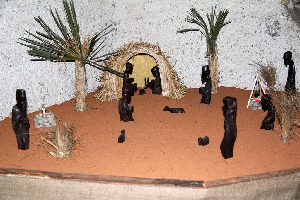 “Presepe in ebano” di Carlo Morandi. Gli abitanti del villaggio accorrono alla capanna per accogliere il nuovo nato. Un presepe costruito con legno d’ebano che porta nel deserto africano.