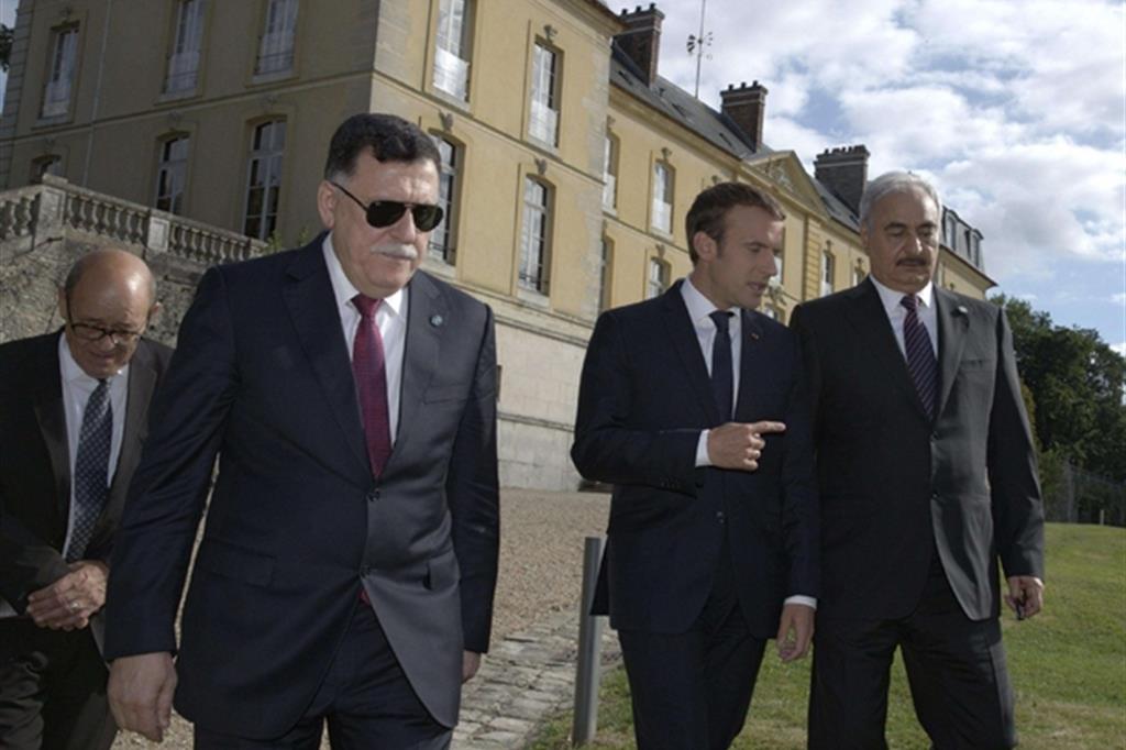 Da sinistra: il premier al-Sarraj, il presidente Macron e il generale Haftar (Ansa)